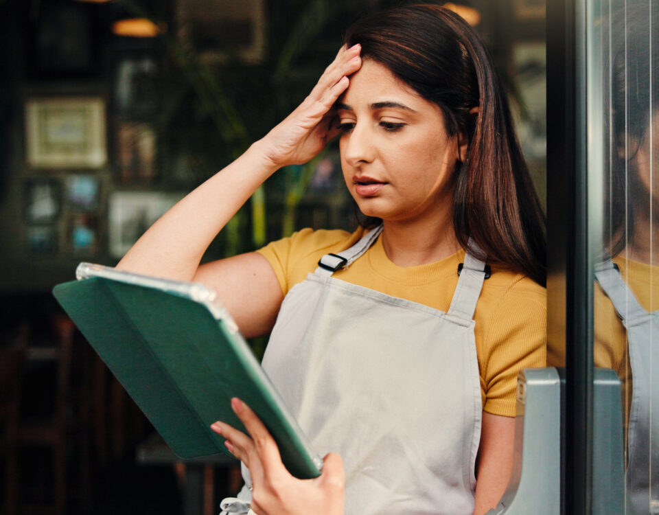 Barista, stress or woman at cafe with tablet for inflation, bankruptcy or financial crisis. Sad, headache or waitress at coffee shop with mistake, fail or reading bad review on social media with tech.